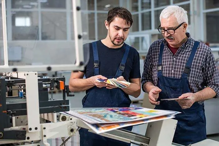 Two men looking at high quality printing in Bestype Printing NYC's local print shop