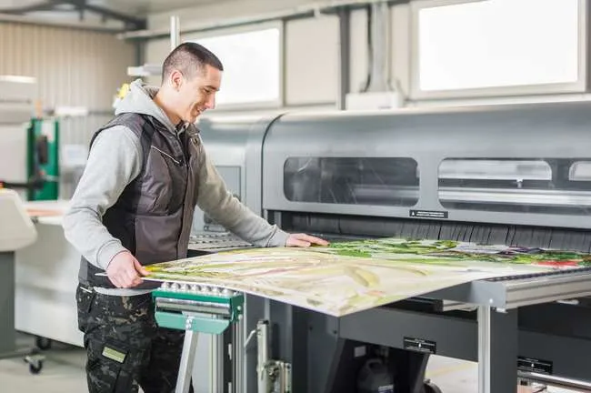 Man working in a print shop doing Custom Poster Printing in NYC